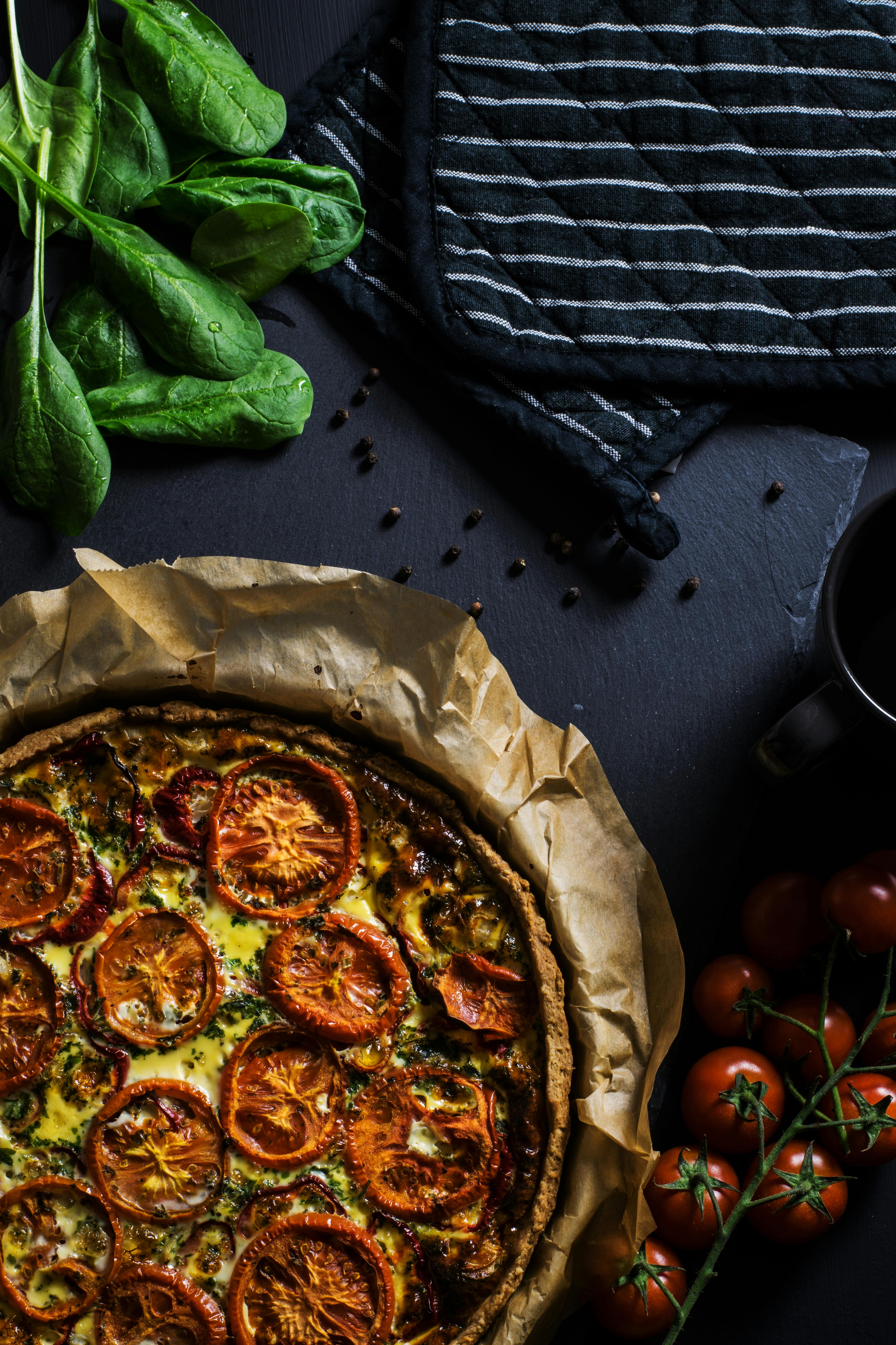 A delicious homemade tomato quiche with fresh spinach, ready to serve, perfect for dinner.